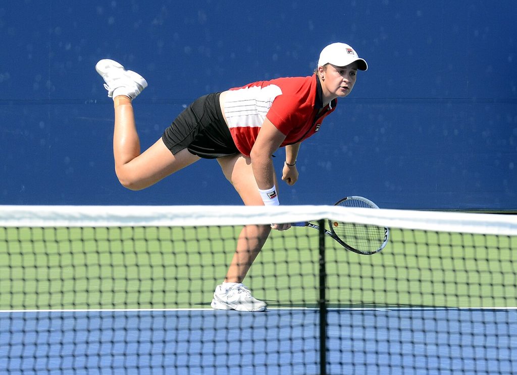 A professional tennis player in action at the net during a match
