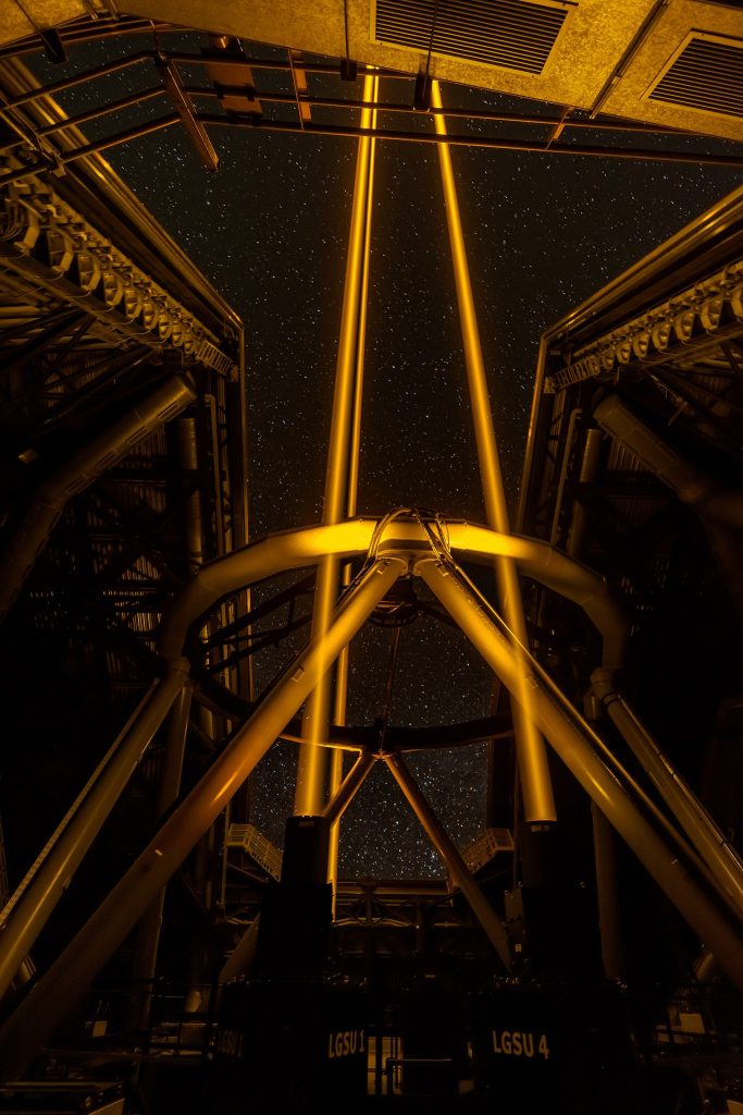 A telescope under a star-filled night sky at an observatory.