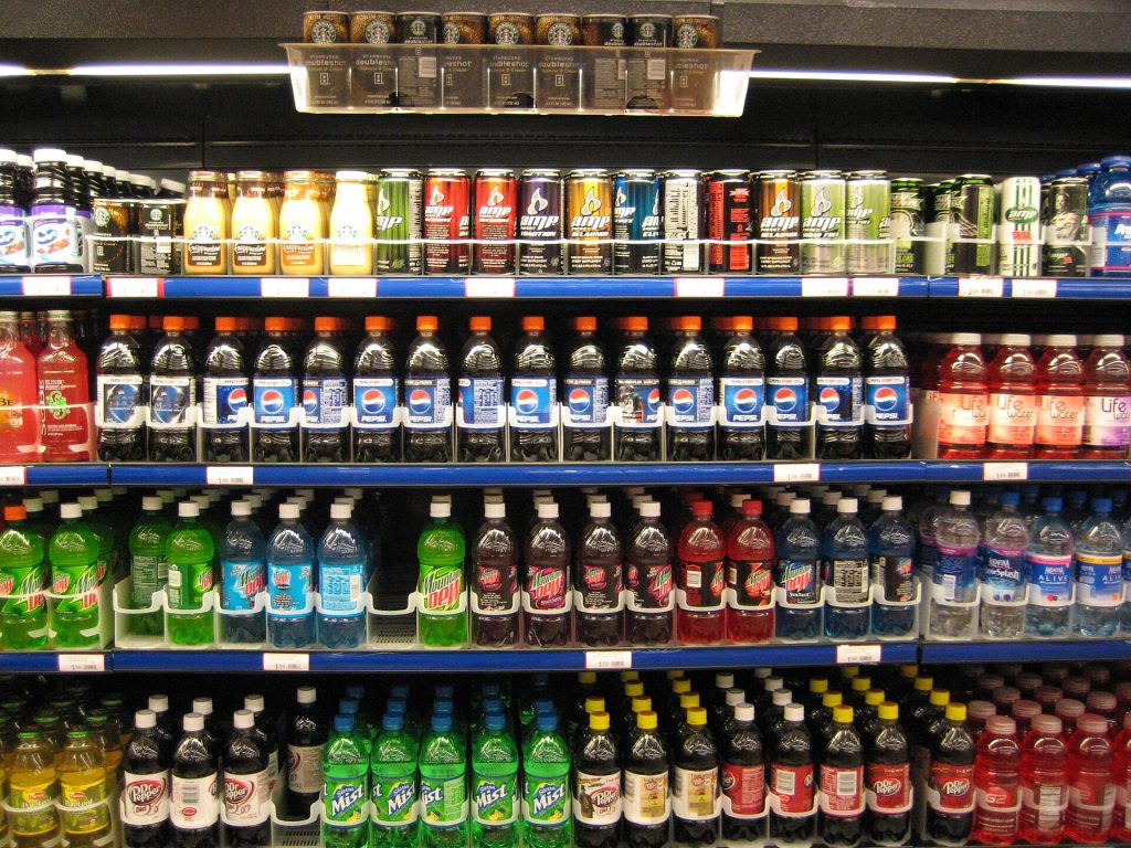 Supermarket shelf with packaged foods and nutrition labels being checked